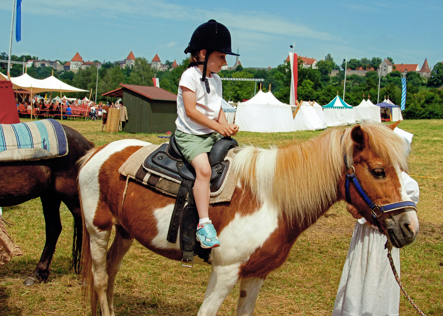 Child riding a pony with a pony saddle