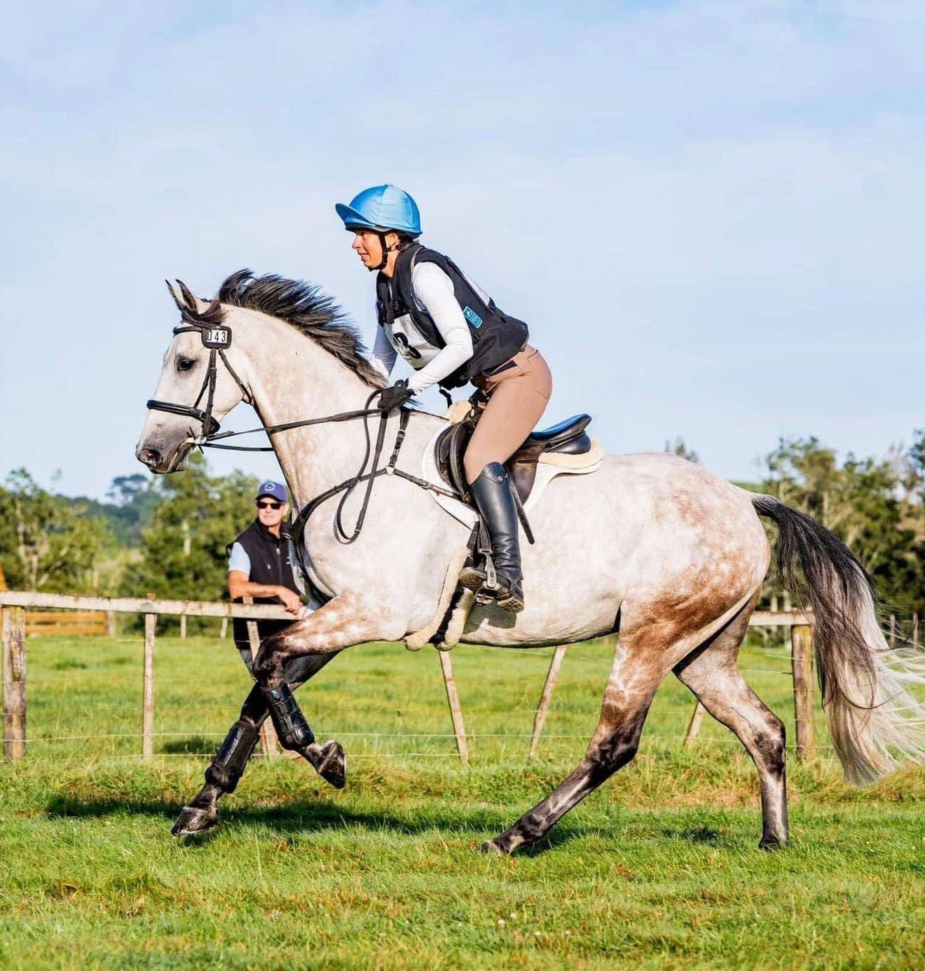 Person riding a horse in an outdoor setting with a clear sky